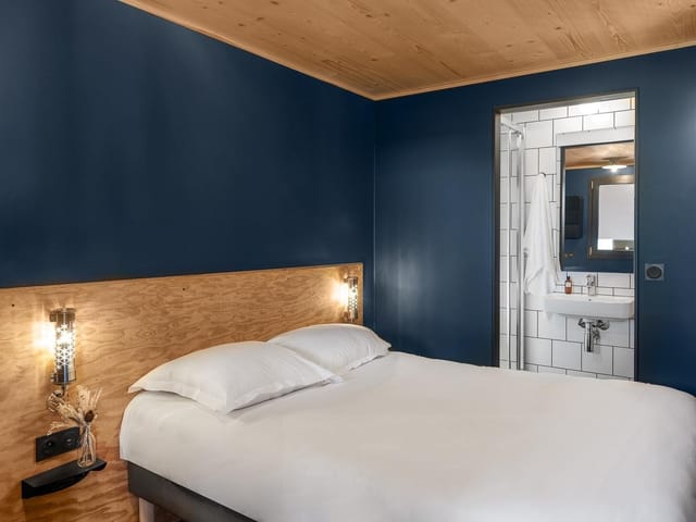 Modern hotel room in Eklo with deep blue walls, perfect for event attendees.