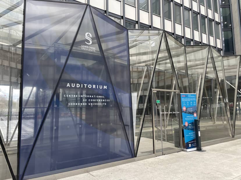 Modern auditorium entrance with glass facade at Sorbonne Université for conferences and events.