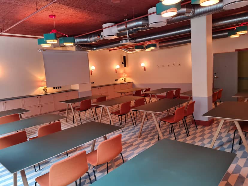 Versatile meeting room with modular tables at 25hours Hotel Indre By for workshops and presentations.