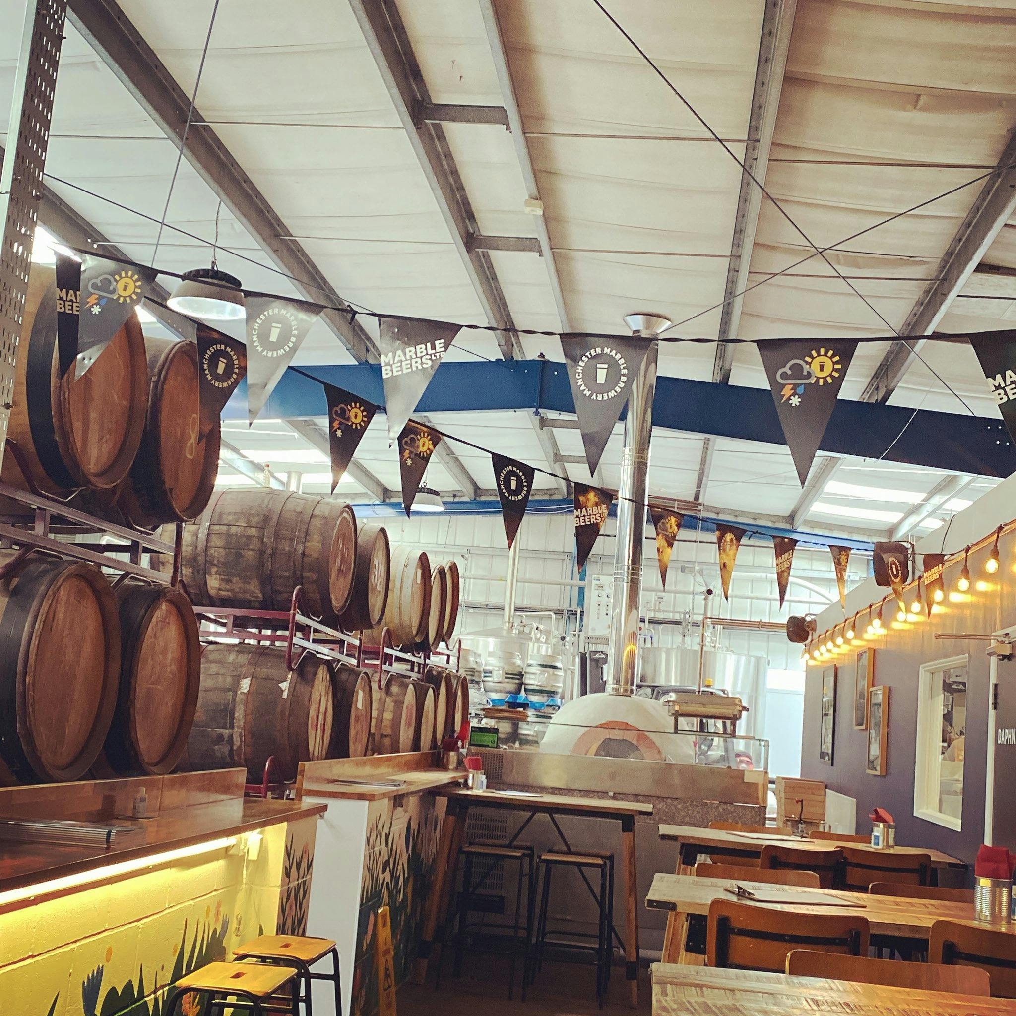 "Vibrant brewery event space with rustic barrels, perfect for gatherings and corporate events."