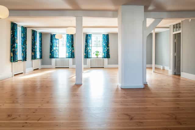 K. Larsen in a spacious, well-lit event space for meetings and workshops.