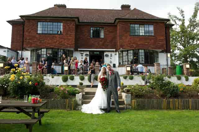 Outdoor wedding at Surbiton Town Sports Club with lush garden and vibrant flowers.