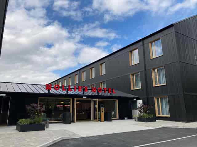 Modern hotel exterior with sleek black wood paneling, ideal for corporate events.