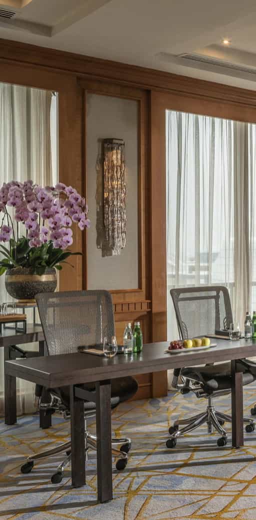 Elegant meeting space at Four Seasons Singapore with orchids, ideal for corporate events.