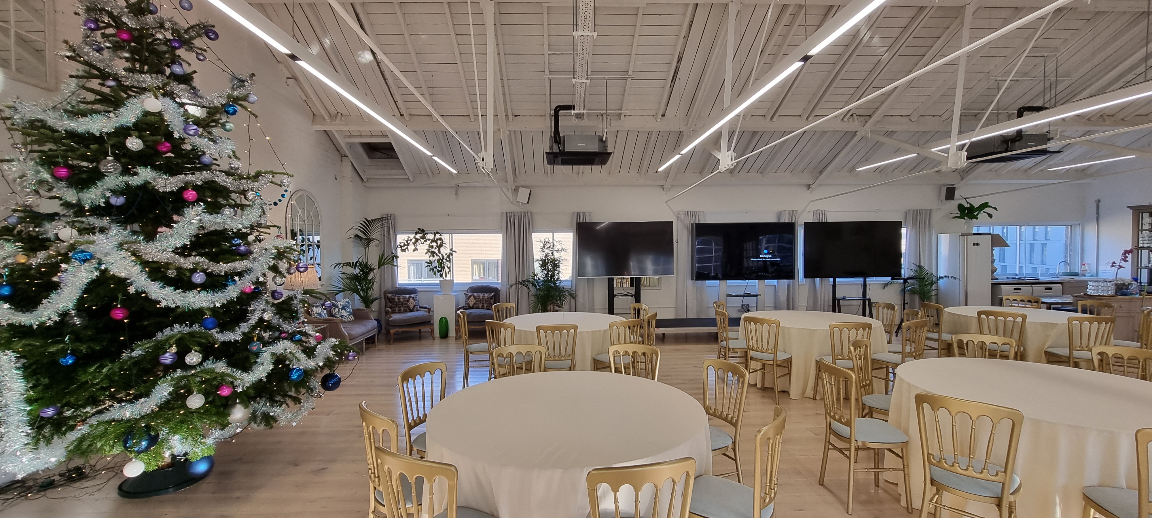 Elegant event space with round tables, perfect for holiday gatherings and corporate meetings. - Banner