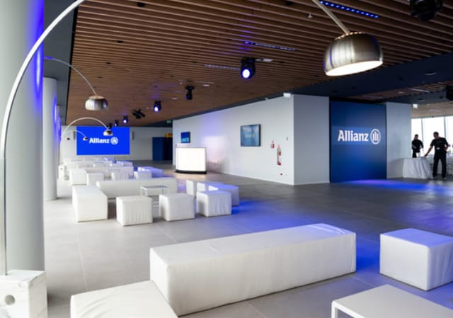Modern corporate event space in Tower 47 Milano with sleek white seating and branding.