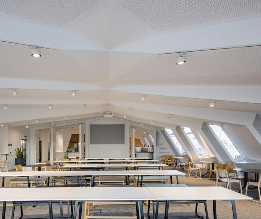 Modern meeting space with sloped ceiling, ideal for workshops and presentations.
