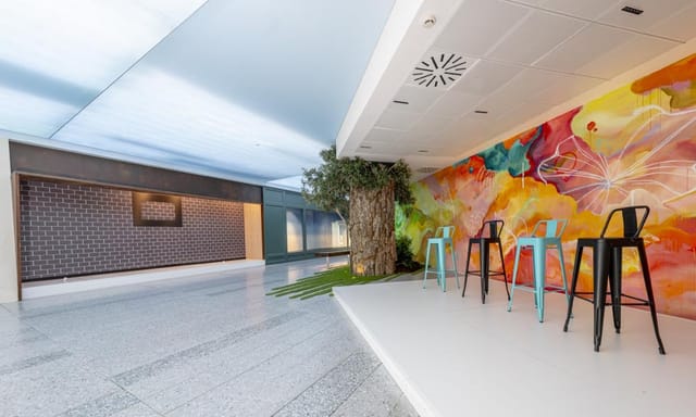 Vibrant Torre Emperador Castellana showroom with colorful mural for workshops and networking.