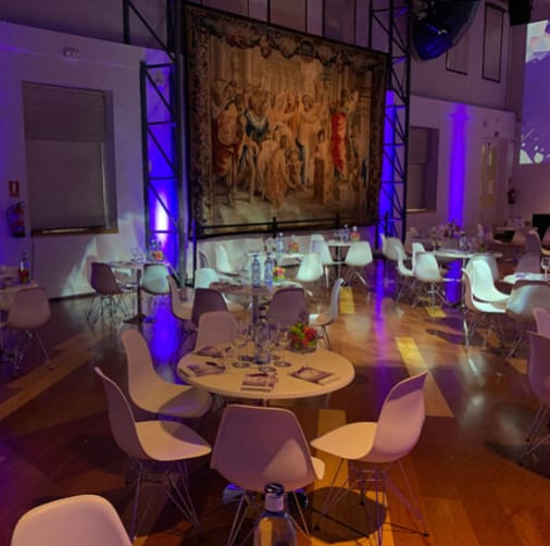 Stylish Sala Goya event space with blue lighting and elegant tapestry backdrop.