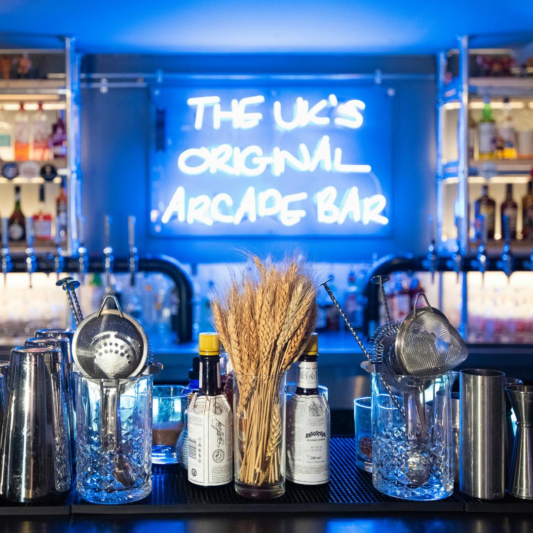 Vibrant arcade bar in Newcastle with neon sign, ideal for networking events and gatherings.