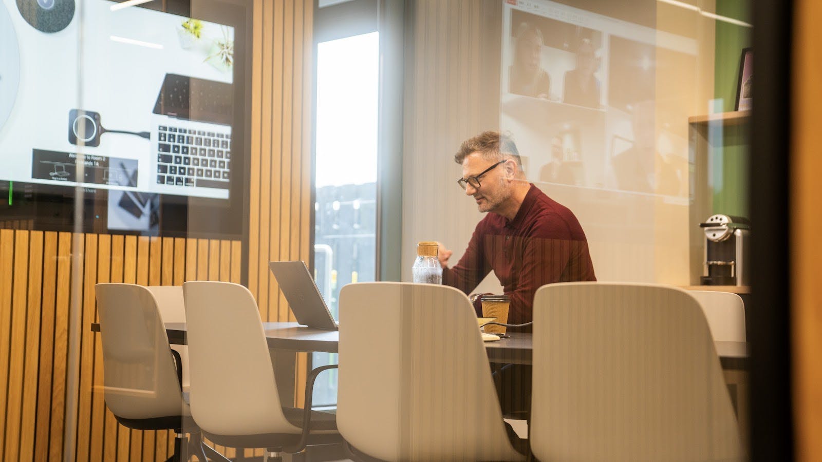 Modern boardroom in Orbit Spaces, featuring glass walls for virtual meetings and collaboration.