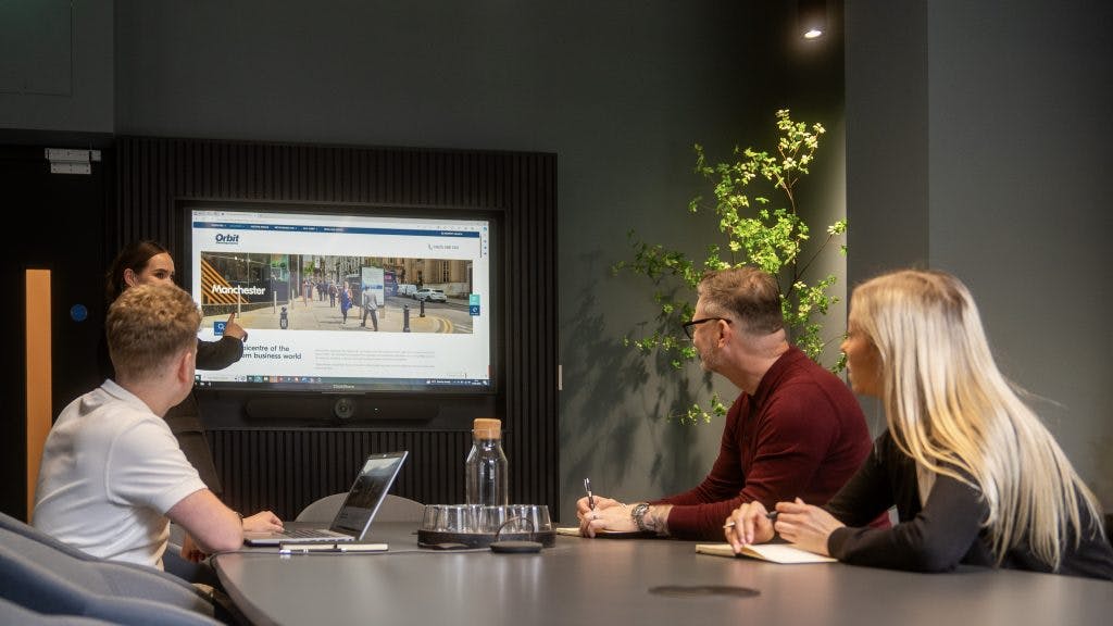 Modern boardroom in Orbit Spaces, featuring digital display for engaging meetings.