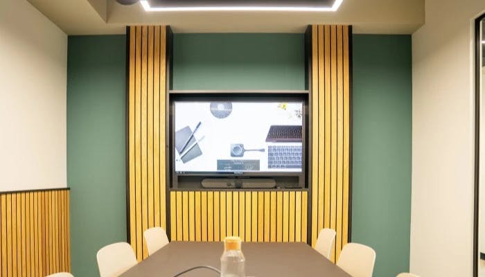 Modern boardroom with large screen, ideal for team meetings and brainstorming sessions.