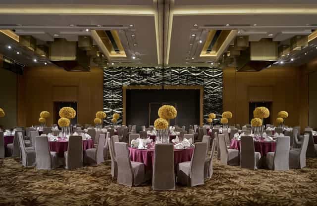 Elegant ballroom setup with floral centerpieces for weddings and corporate events.