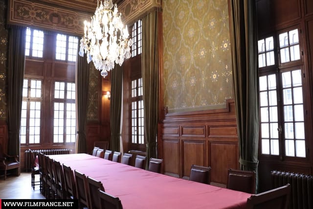 Elegant meeting room with long table, chandelier, ideal for corporate events.