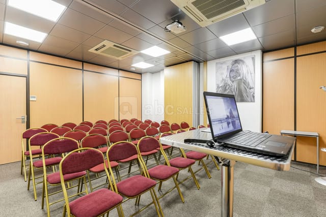Meeting room with red chairs and podium, perfect for presentations and workshops.