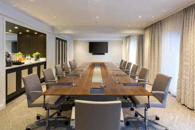 Modern conference room at Hilton Paris Opera with long table, ideal for meetings and presentations.