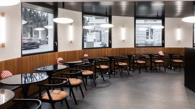 Modern café venue with round tables, ideal for networking events and meetings.