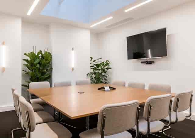 Modern conference room with wooden table, ideal for professional meetings and presentations.