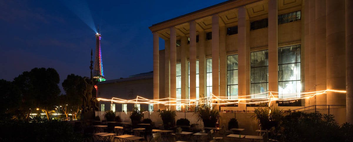 "Orbe NY event at Palais de Tokyo with modern architecture and string lights ambiance"