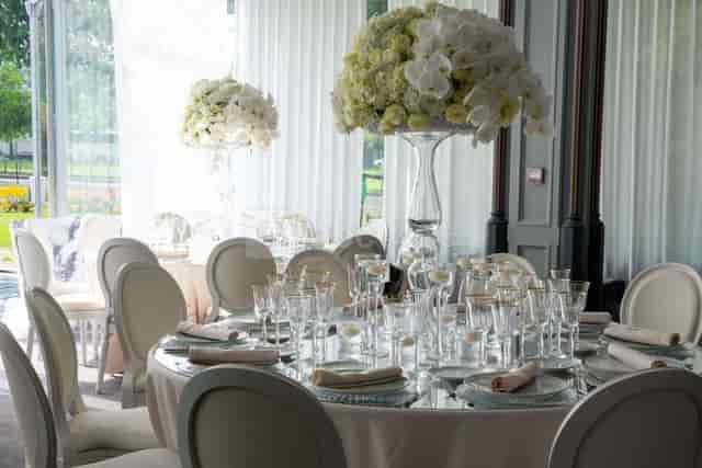 Elegant dining table with floral centerpieces for weddings or corporate events.