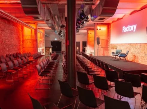 Event space in Factory Berlin Mitte with chairs and stage for conferences and workshops.
