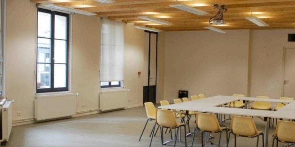 Versatile meeting space with natural light at Maison des Métallos for workshops and events.