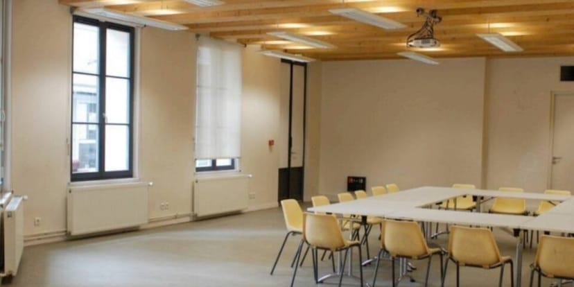 Versatile meeting space with natural light at Maison des Métallos for workshops and events.