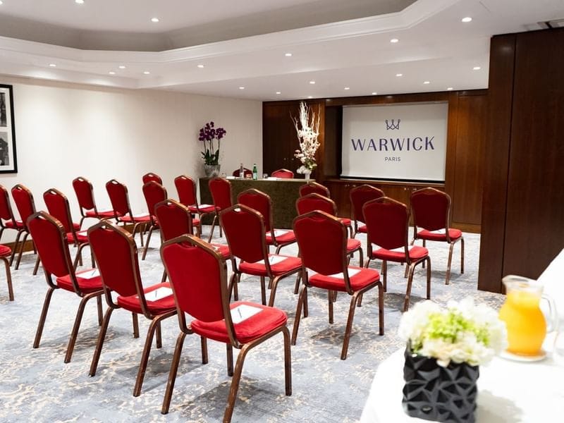 James Dean in a professional meeting room with red chairs, ideal for corporate events.