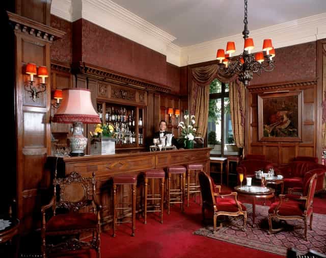 Elegant bar at Hôtel Raphael with rich wood paneling, perfect for networking events.