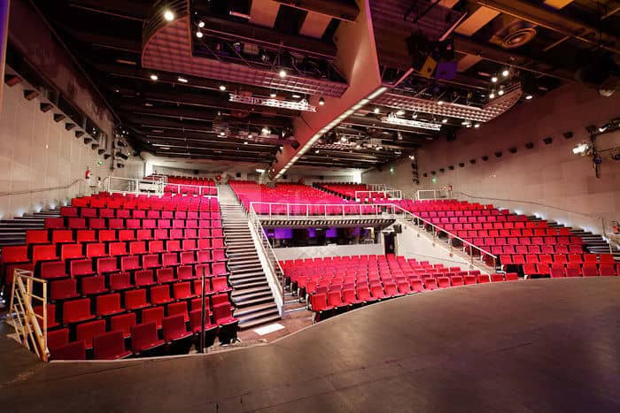 Modern auditorium with tiered red seating at Cité des Sciences for conferences and presentations.