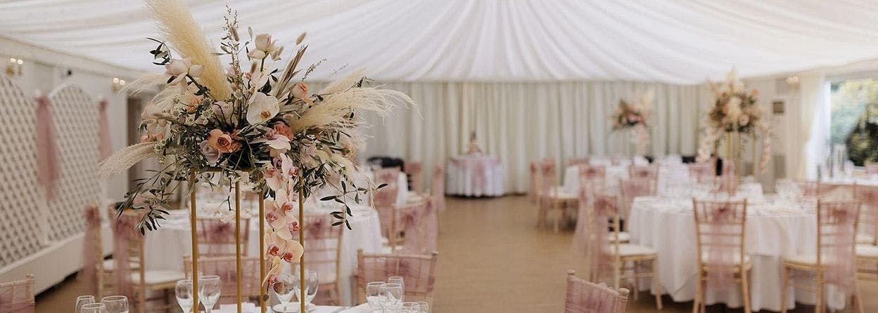 Chandelier-lit pavilion with elegant tables, perfect for weddings and upscale events.