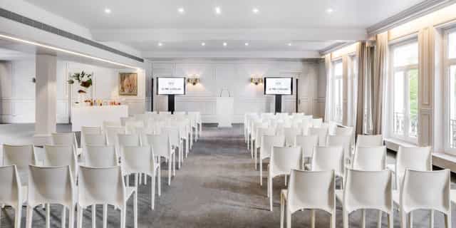 Louis XVI meeting space with white chairs, ideal for corporate conferences and events.
