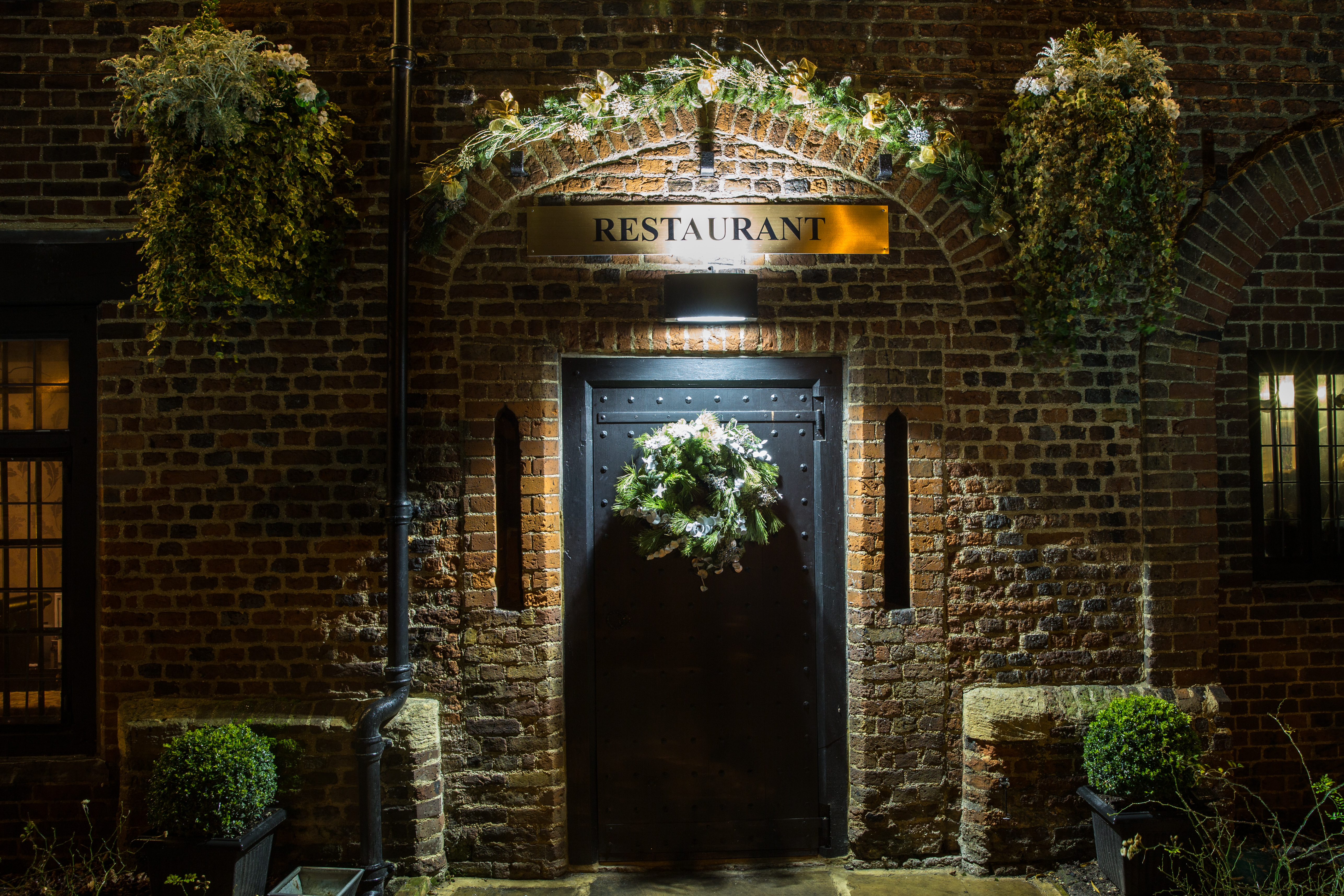 Gastro Pub entrance at Tudor Barn Eltham, adorned with flowers for upscale events. - Banner