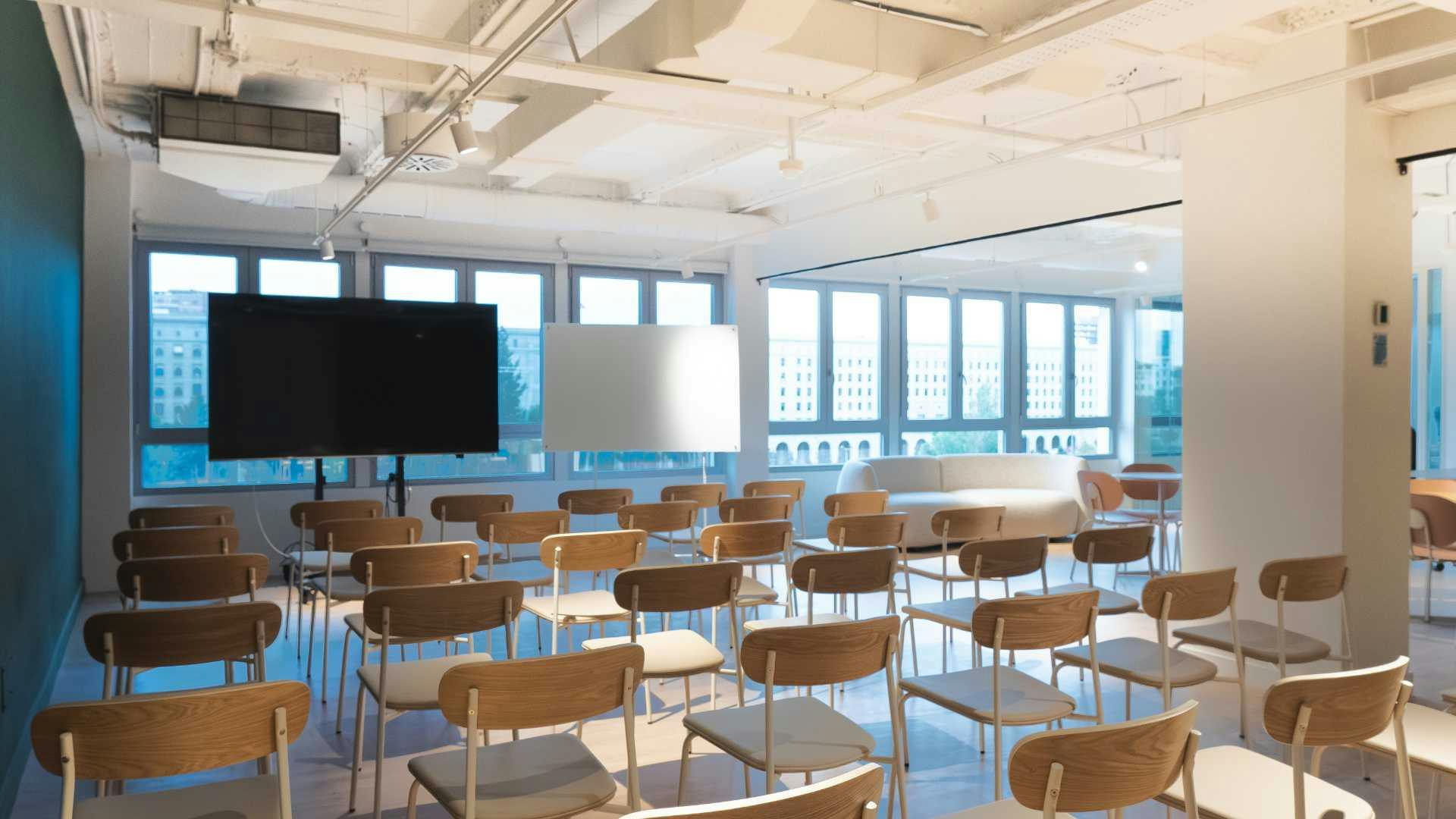 Modern workshop room with natural light, ideal for seminars and events.