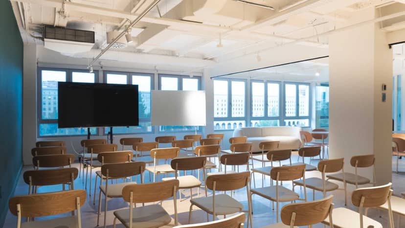 Modern workshop room with natural light, ideal for seminars and events.