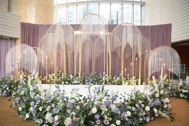 Elegant event stage with gold arches and floral decor at Four Seasons Hotel Hong Kong.