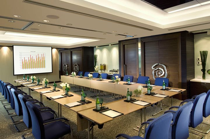Banquet hall with U-shaped table setup for professional meetings at Regal Airport Hotel.