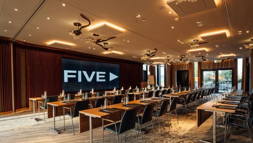 Modern conference room in FIVE Zurich with U-shaped tables for meetings and presentations.
