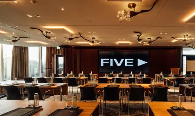 Modern ballroom in FIVE Zurich with large screen, perfect for corporate events.