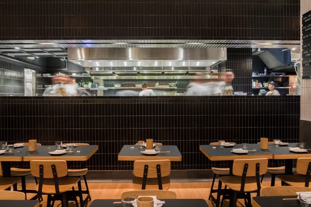 Modern restaurant backroom with open kitchen, ideal for culinary events and private dining.