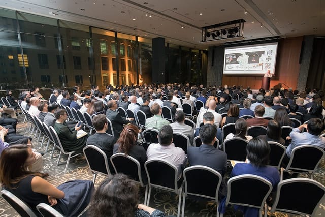 Hong Kong Jockey Club Hall conference with engaged audience and modern technology setup.