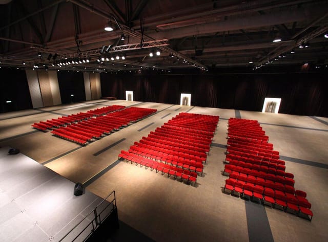 Runway 11 at AsiaWorld-Expo with red chairs, perfect for conferences and presentations.