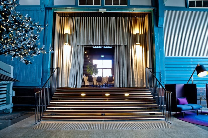 Stylish event space at Ovolo Hotels with elegant curtains and vibrant blue walls.