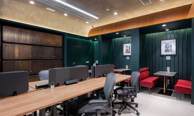 Modern co-working space with wooden desks, ideal for meetings and events.