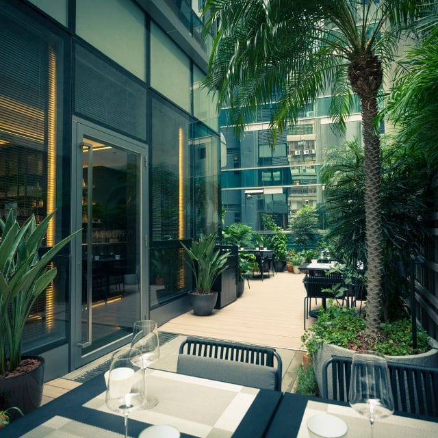 Stylish outdoor dining space at Arcane, ideal for events with lush greenery and modern decor.