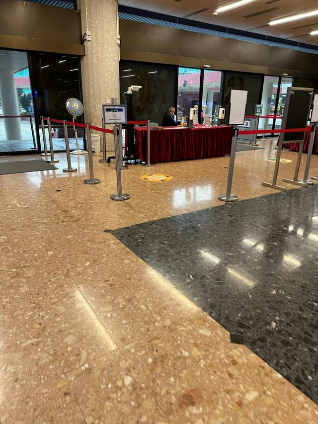 Tuen Mun Town Hall conference room registration area with check-in desk and stanchions.