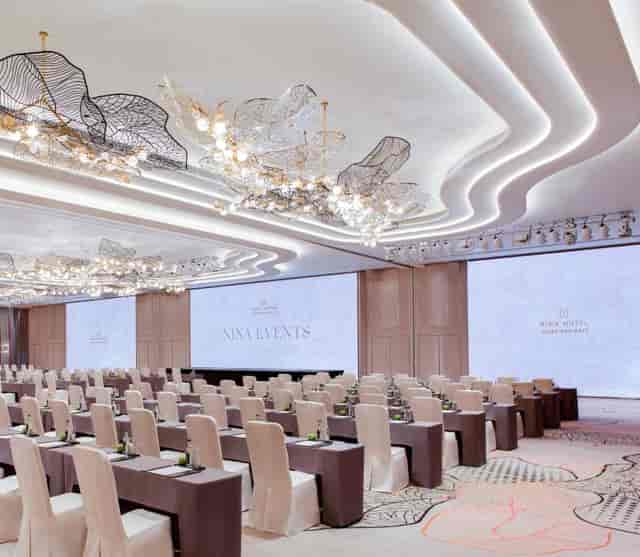 Sky Lounge at Nina Hotel: elegant corporate event space with modern decor and large screens.