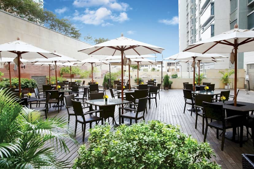 Garden Room at Harbour Plaza 8 Degrees, outdoor event space with tables and umbrellas.