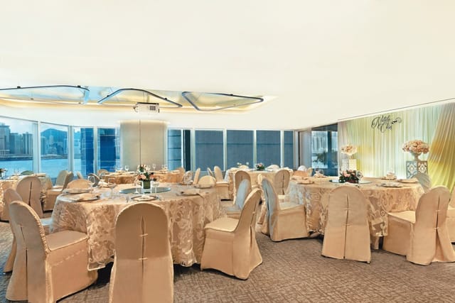 Elegant event space with gold tablecloths and floral centerpieces at Harbour Grand Kowloon.